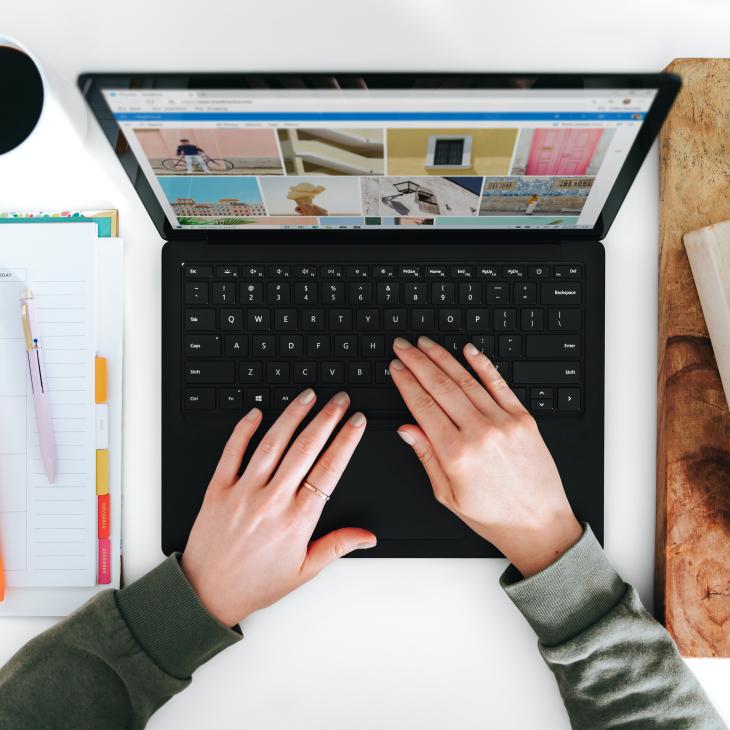 View of laptop from above with two hands on keyboard