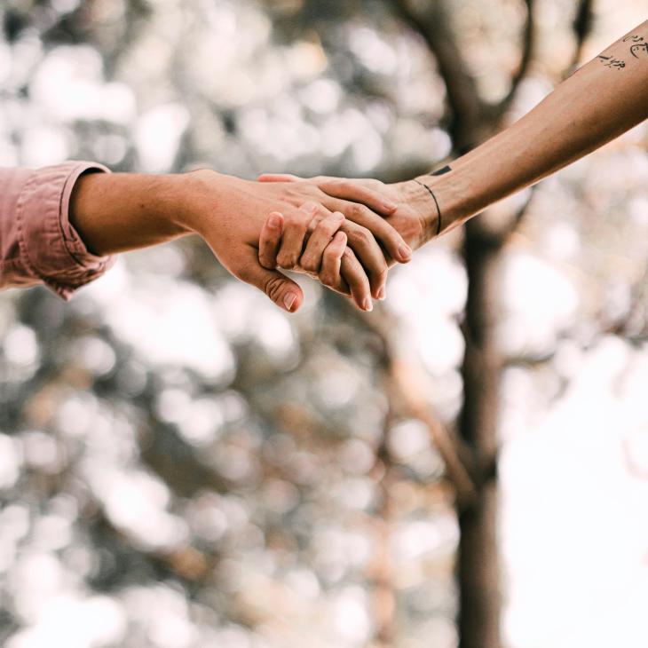 An image of two hands clasped together in help and friendship.