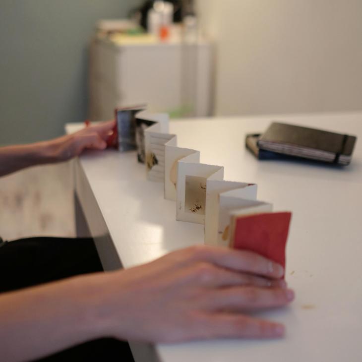A handmade accordion fold zine stretched out on a table