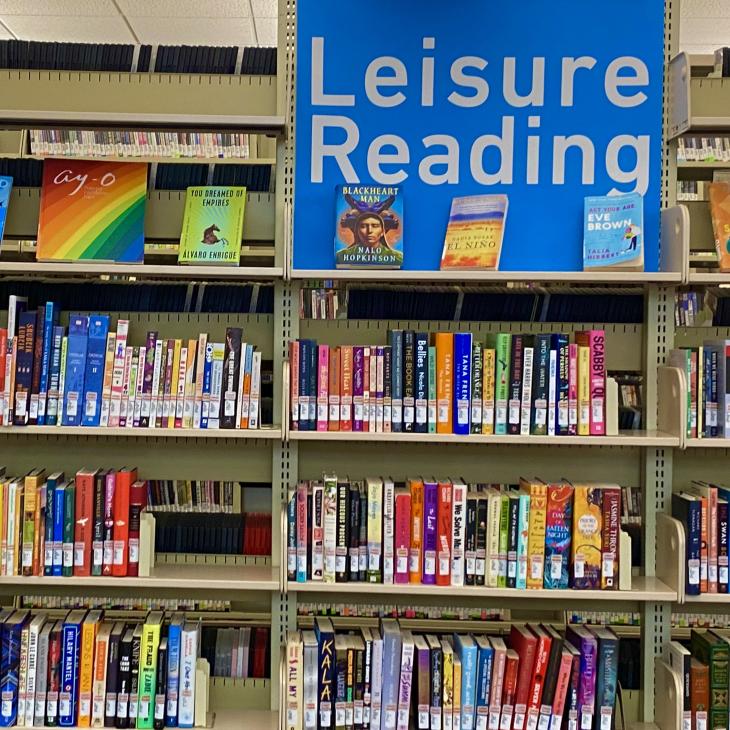 Photo of library book stacks with a sign that says Leisure Reading