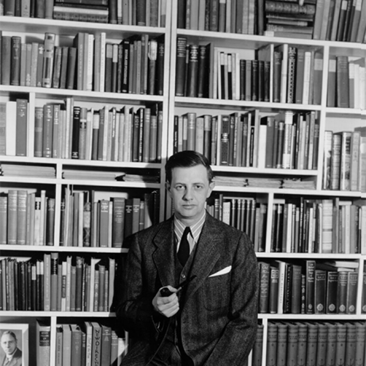 John Holmes in front of tall and wide book shelves 