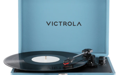 Light blue Victrola suitcase record player, opened up with a record on the turntable and the needle on the record.