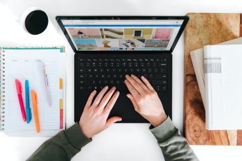 View of laptop from above with two hands on keyboard