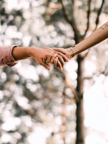 An image of two hands clasped together in help and friendship.