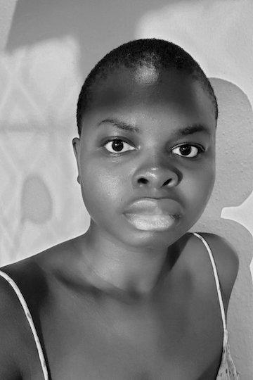 Black and white portrait of black non-binary person looking directly into the camera