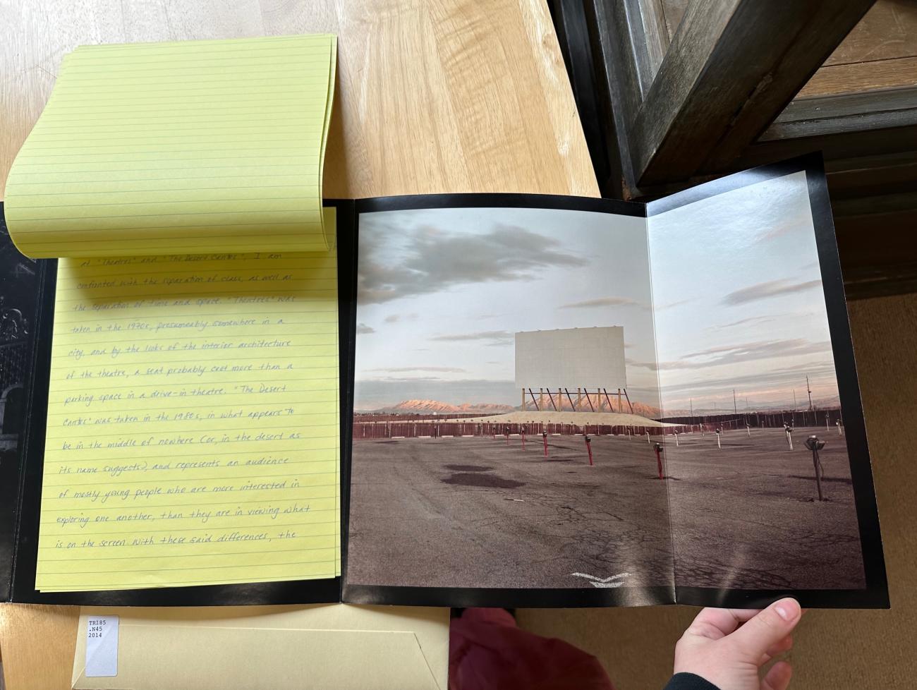 An open book showing a photograph and yellow legal pad