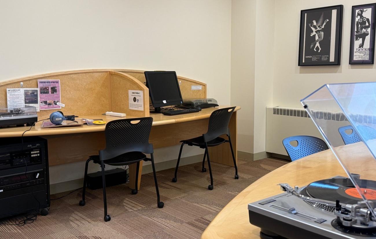 Audio workstations with LP player on top of desk, headphones sitting on top of some records, and a CD player under the desk.