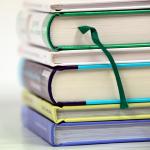 Stack of 6 books, showing spines & bottom of books